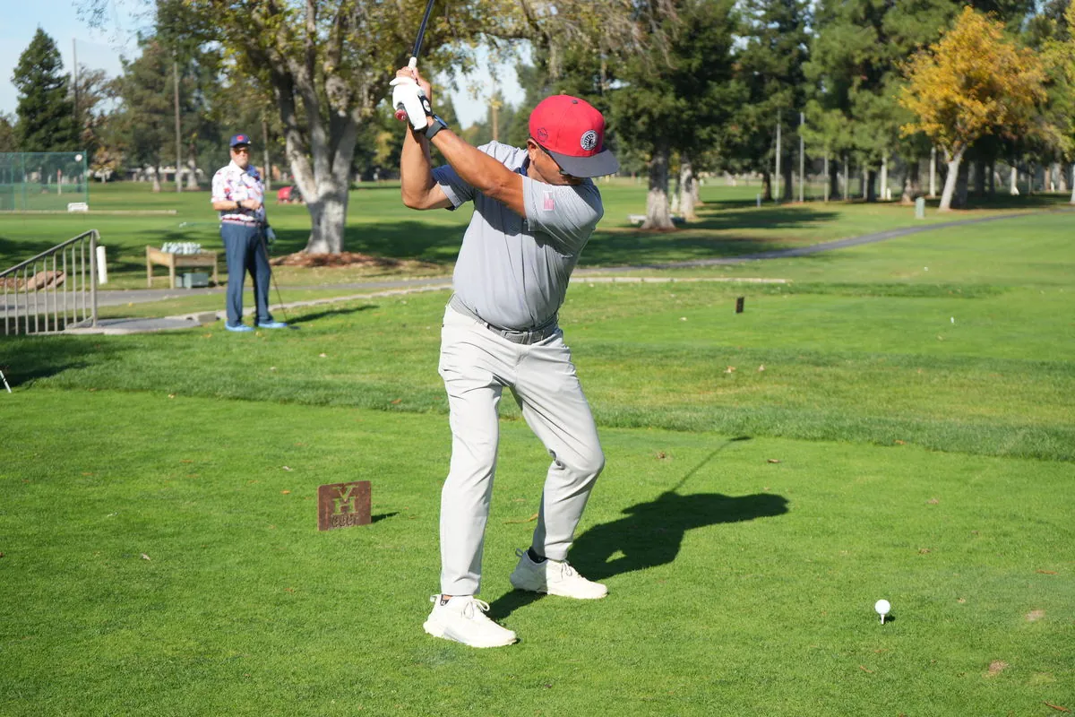 A participant follows through on a tee shot